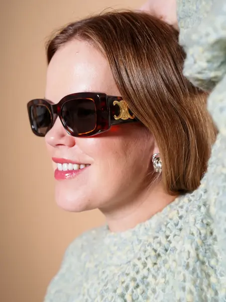 Dame med brune Celine solbriller med gull-logo på siden