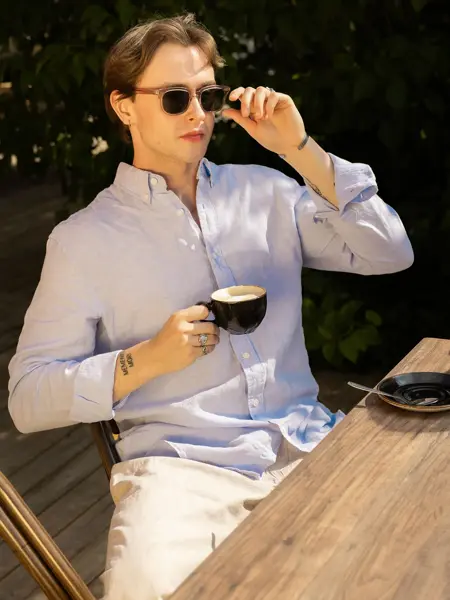 Mann som sitter og drikker en kopp kaffe