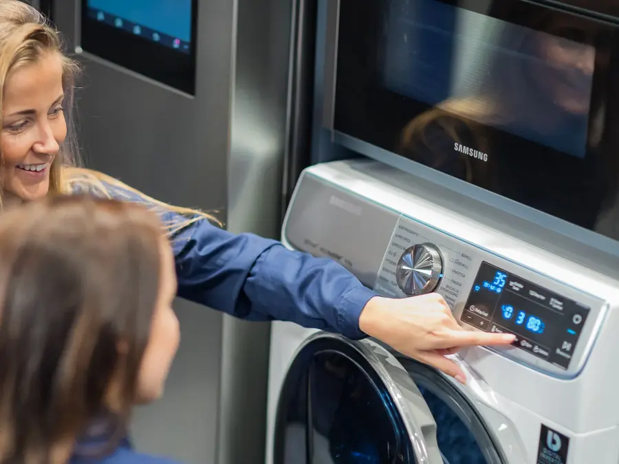 Jenter ser på vaskemaskin hos Elkjøp