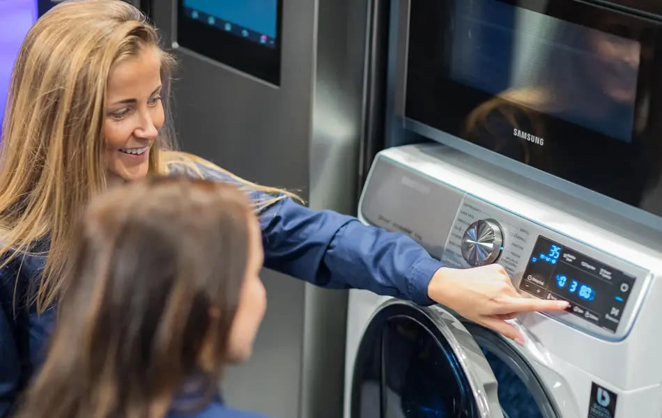 Jenter ser på vaskemaskin hos Elkjøp