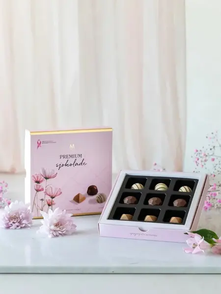 Rosa eske med konfekt på et bord, rosa blomster som pynt