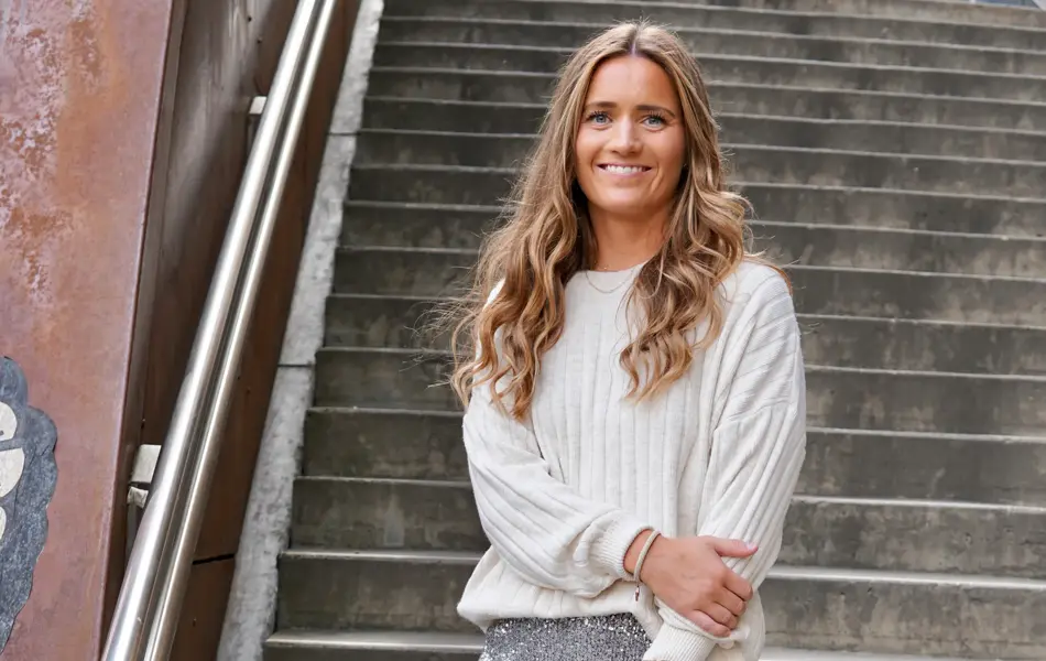 Dame med sølv glitter skjørt, svarte boots og hvit genser