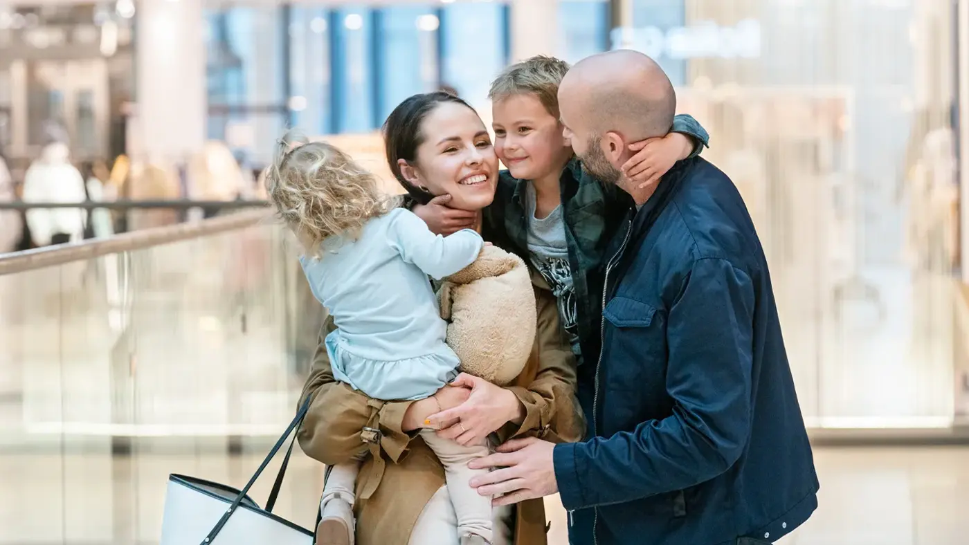 Familie med kvinne, mann og to små barn på shopping