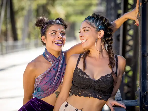 to smilende unge damer med glitter i håret og festival klar