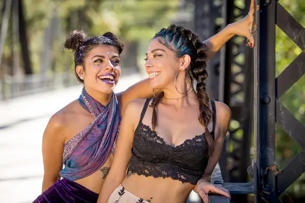 to smilende unge damer med glitter i håret og festival klar