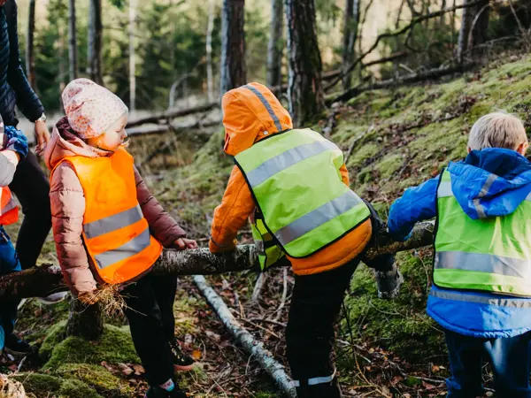 barn med refleksvest på seg ute i skogen