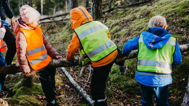 barn med refleksvest på seg ute i skogen