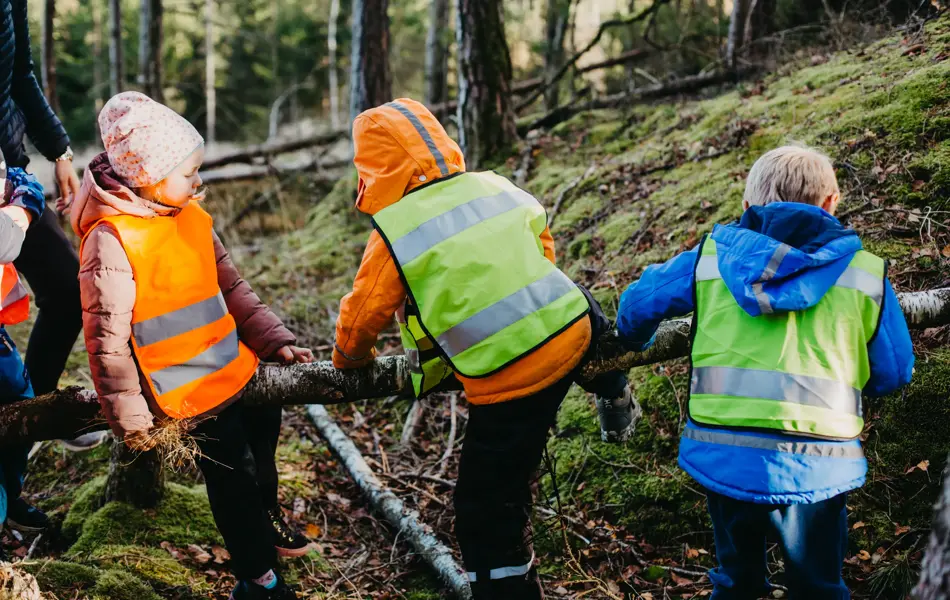 barn med refleksvest på seg ute i skogen