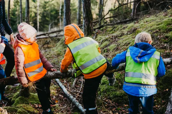 barn med refleksvest på seg ute i skogen