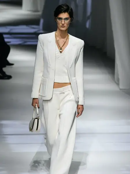 Dame som går på catwalk med hvit dress og hvit topp inni. 