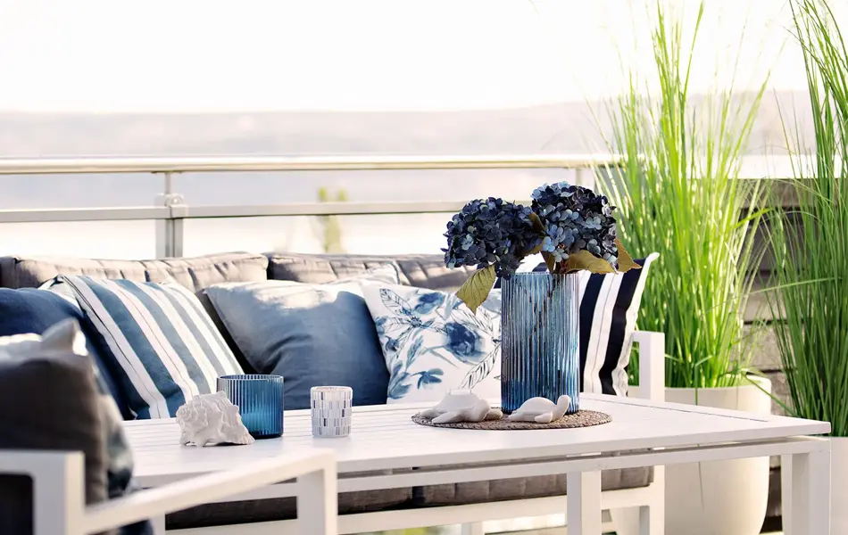 Ute sittegruppe dekket med blåputer og grønne planter