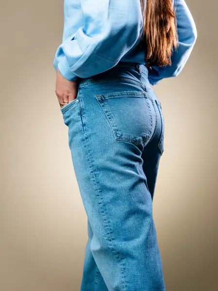 Vårens trender vist av en jente med halvlangt lyst hår og en jente med mørkt langt hår. Beige trenchcoat, kanll rosa skjorter og kjoler og bluser med puffermer