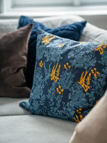 Utvalgte blå og brune puter i beige sofa