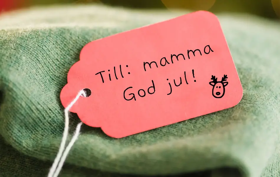 Grønn strikket genser med en rød lapp