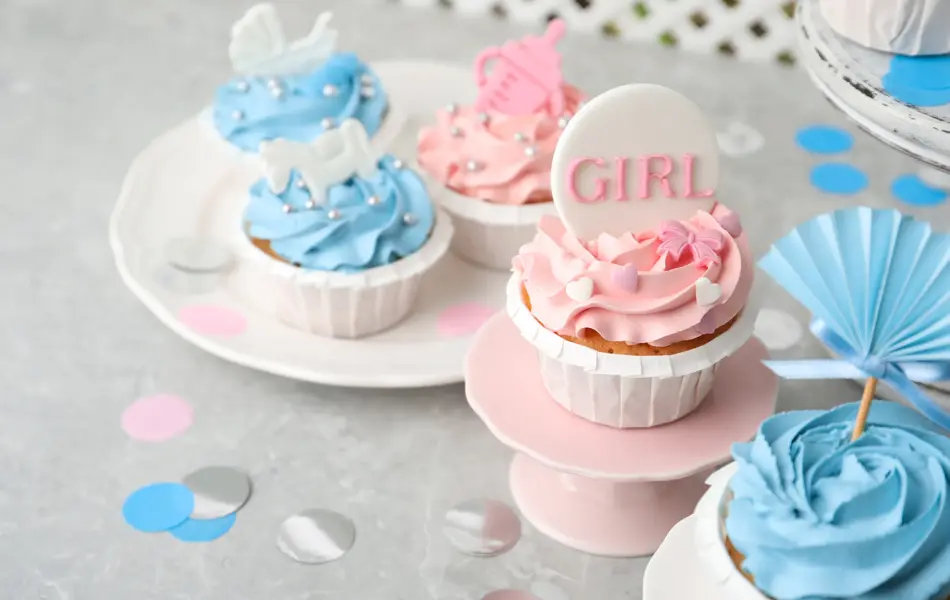 Delicious cupcakes with light blue and pink cream for baby shower on grey table
