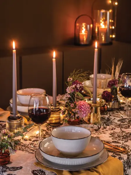 Dekket bord med servise og tent lysestaker