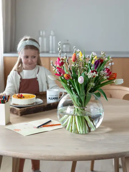 Barn med kake og blomster på et bord