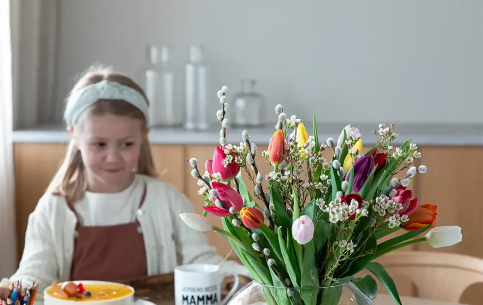 Barn med kake og blomster på et bord
