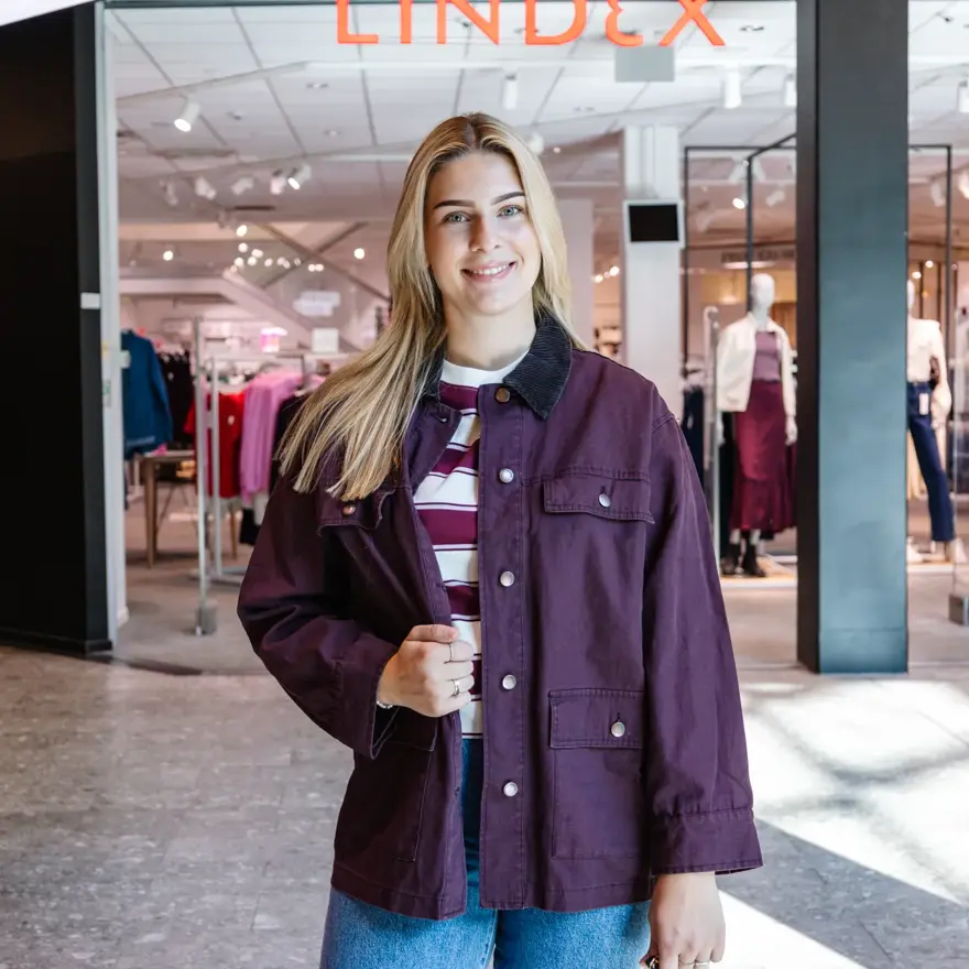 dame i antrekk utenfor butikk