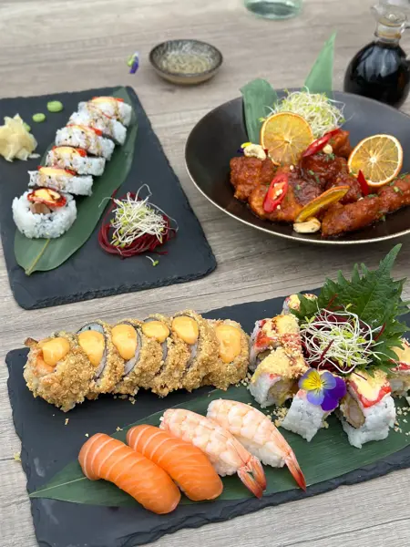 Sushi og orange chicken på fat