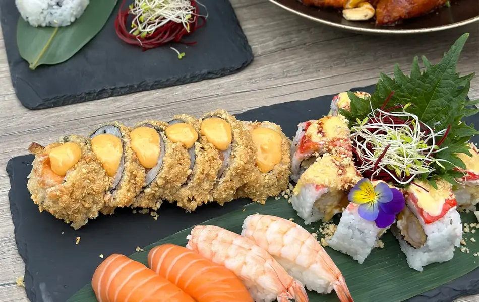 Sushi og orange chicken på fat