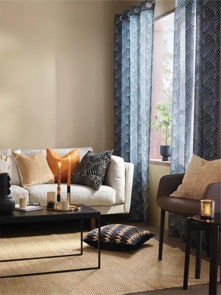 Sofagruppe med blå gardiner og brunevegger i bakgrunn