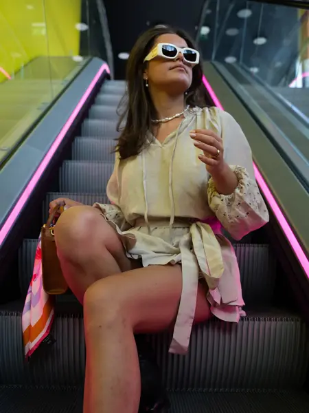 Dame som sitter i rulletrapp