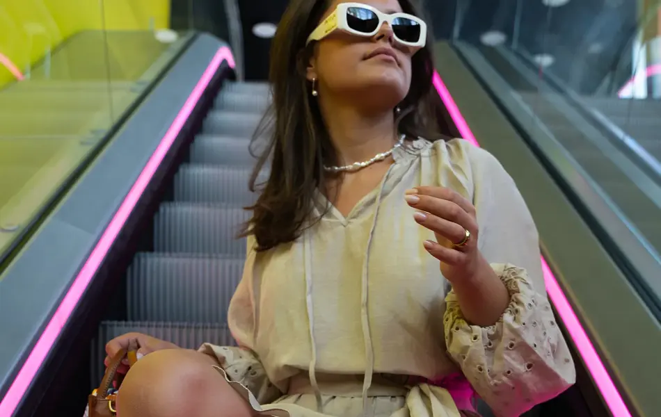 Dame som sitter i rulletrapp