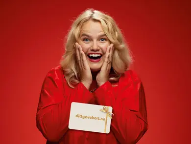 Ung dame som smiler med dittgavekort med juledesign