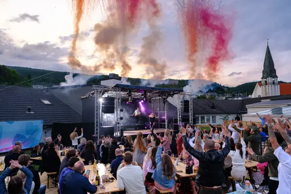 Dagny fremfører for en gjeng på utekonsert med pyro effekter