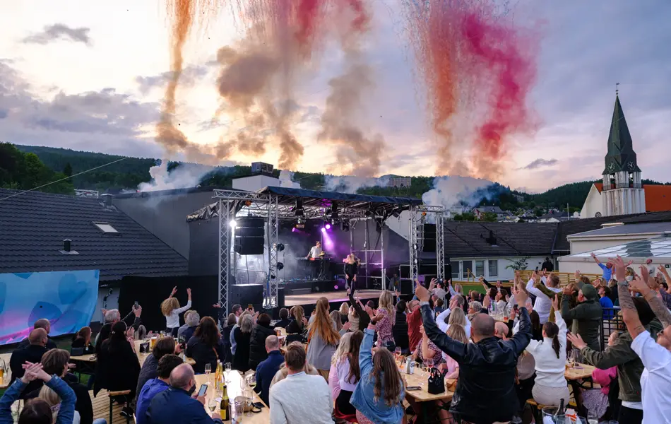 Dagny fremfører for en gjeng på utekonsert med pyro effekter