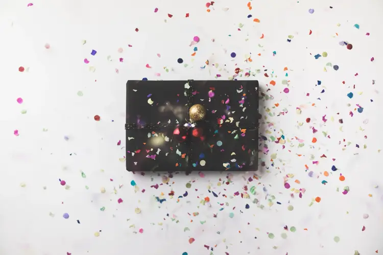 Black wrapped Christmas gift box on white background