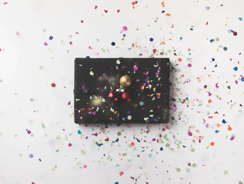 Black wrapped Christmas gift box on white background