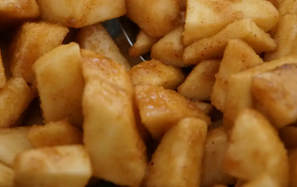 Bolle med eplebiter som er rørt inn med brunt sukker