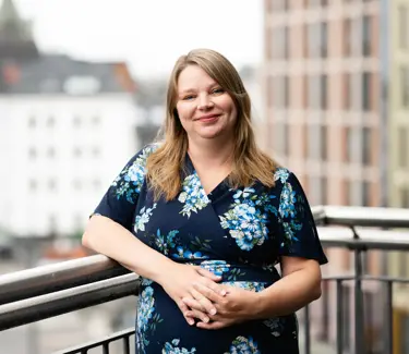 Portrett av Anna Marie Fjeld. Hun står foran et gjerde. 