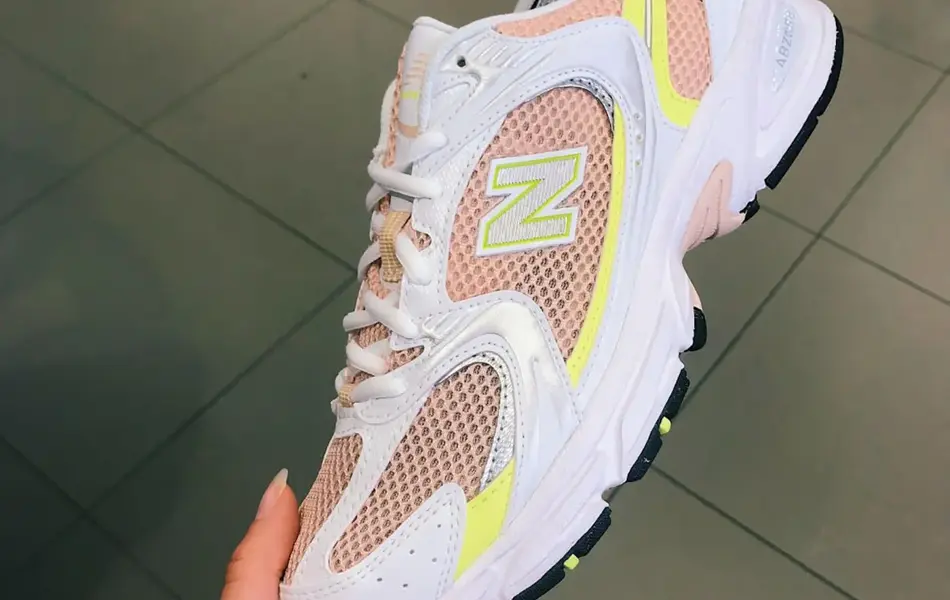 Nærbilde av en joggesko som blir holdt opp av en hånd