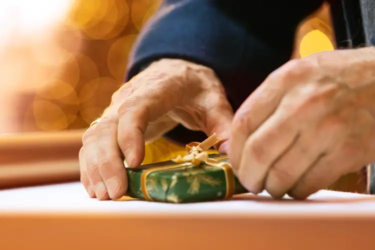 Mannehender pakker inn gave