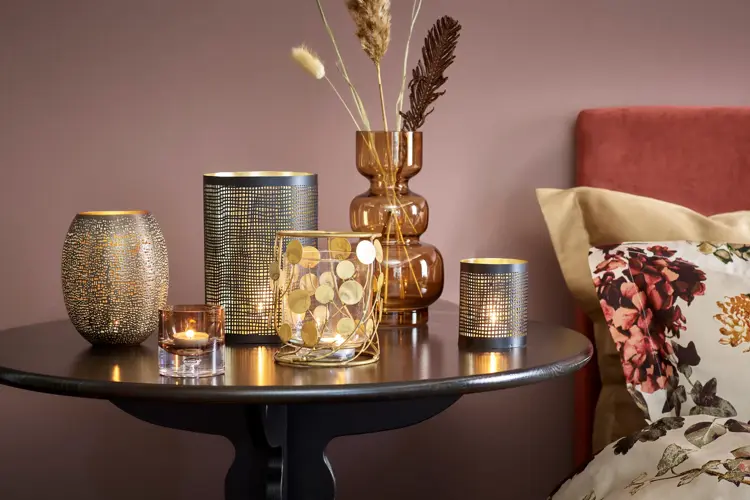 INNEHYGGE med levende lys og dekorative kvister.