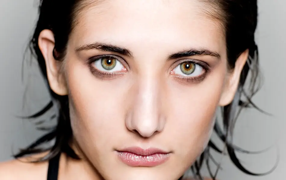 beauty portrait of young woman with beautiful green-blue-brown eyes.