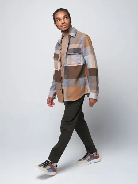 mann med rutete høstjakke som går og ser opp