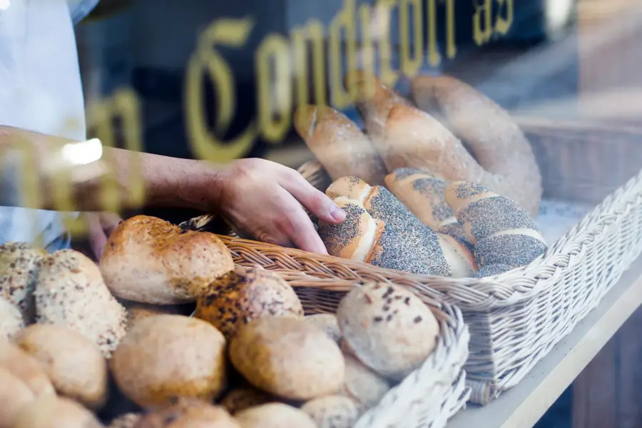 Hånd tar på ferskt bakverk i disken
