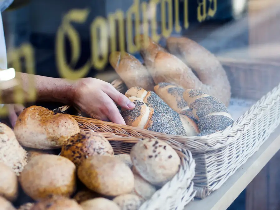 Hånd tar på ferskt bakverk i disken
