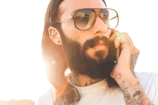 Nærbilde av tatovert mann med store solbriller 