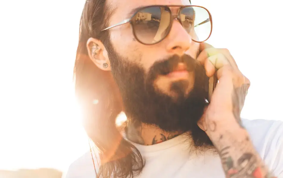 Nærbilde av tatovert mann med store solbriller 