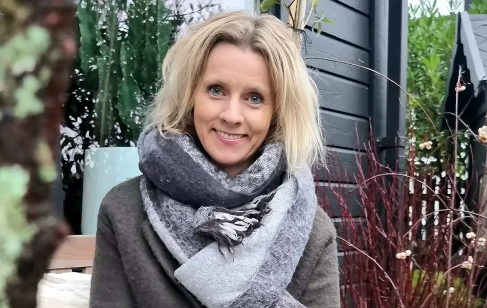 Kvinne, Marita Ryland  poserer for et bilde i hagen sin. 