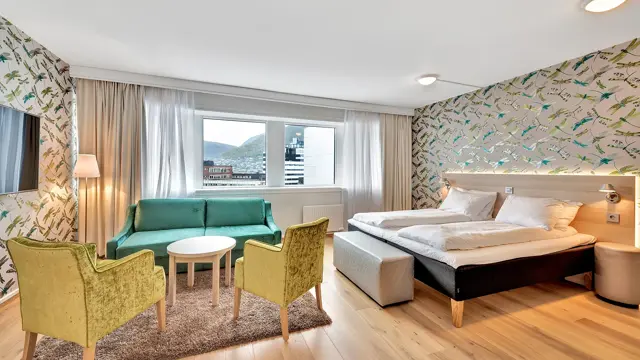 Seng, sittegruppe, sofa og vinduet på et businessrom på Thon Hotel Polar