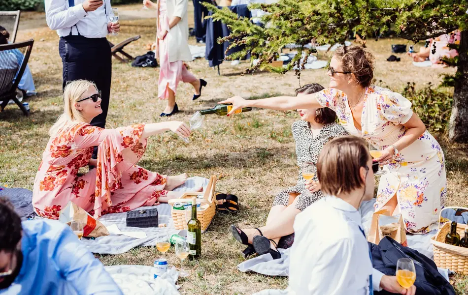 Sommerlig kledde bryllupsgjester har piknik