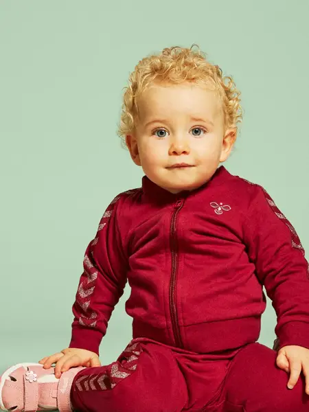 Lite barn som sitter med sandaler