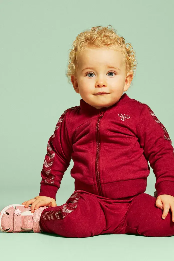 Lite barn som sitter med sandaler