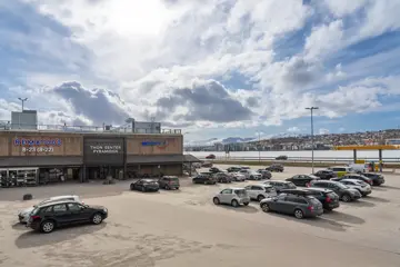 Thon Senter Pyramiden fasade, med parkeringplass og logo over inngang.
